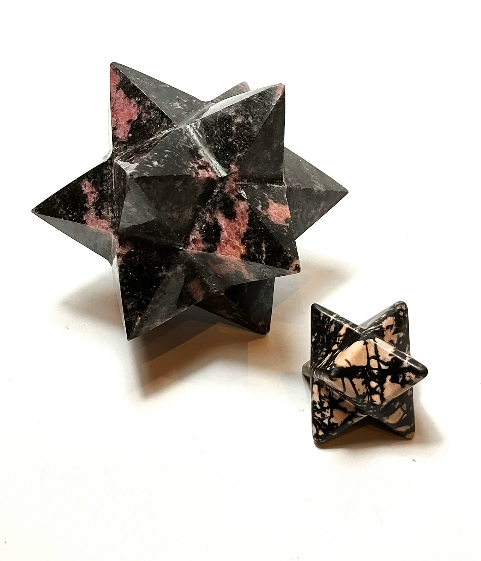 Natural crystals: hand carved and polished Rhodonite dodecahedron (ten pointed star) and Merkabah